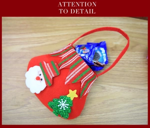 Detail of red Christmas felt gift bag featuring 3D Santa Claus and tree ornaments