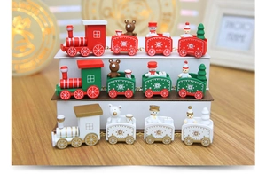 Detailed view of three festive wooden Christmas train sets in red, green, and white