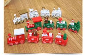 Detailed view of three mini wooden Christmas trains with snowmen and gift figurines
