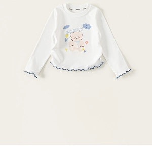 Detail of white cotton girl's t-shirt showing cute bear print and frill edge hem