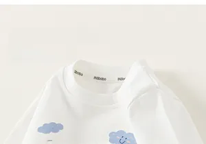 Detail of white cotton kids long sleeve tee showing blue cloud print and soft collar texture