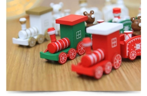 Close-up of wooden Christmas train toy with painted bears and snowflakes on a table