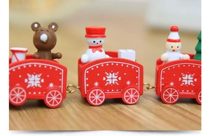 Macro view of a red wooden Christmas train with miniature snowman and Santa Claus figures