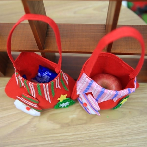 Christmas snowman and Santa gift tote bags filled with apples on wooden surface