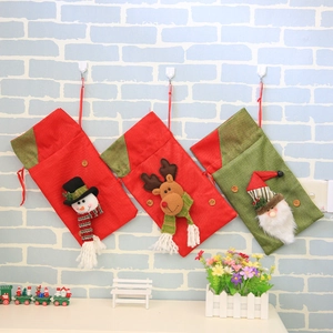 Three Christmas gift bags featuring snowman, reindeer, and Santa designs in red and green