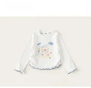 Detail of white cotton girls long sleeve t-shirt with pink bear and blue ruffled edges