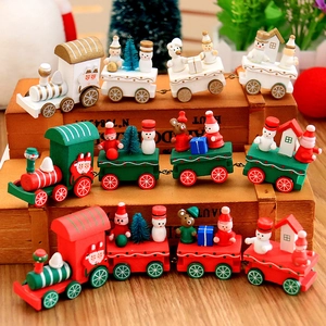 Three colorful wooden Christmas train ornaments with snowman and Santa figures on wooden box
