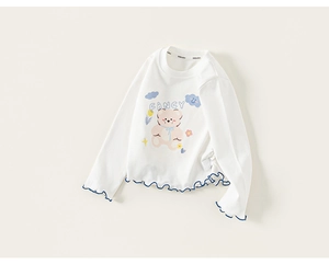 Detail of girls' white long-sleeve cotton T-shirt featuring blue ruffled lettuce edges