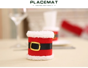 Close-up of Santa suit style napkin ring with red plush fabric and golden buckle detail