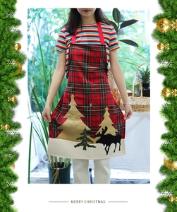 Close-up of Christmas apron with red tartan pattern and festive reindeer tree embroidery