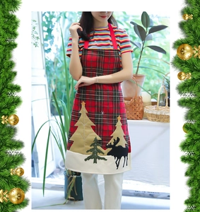 Detailed view of Christmas linen apron featuring classic red-green plaid and reindeer applique