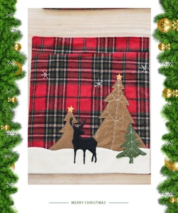 Détail du set de table de Noël avec carreaux rouges, renne et broderie de sapins