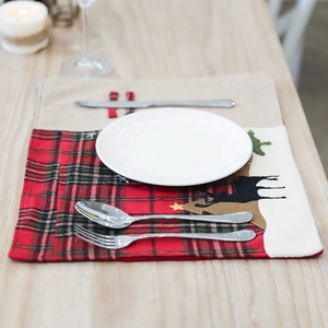 Set de table de Noël en lin avec broderie renne disposé sur une table chaleureuse