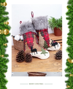 Détail de chaussette de Noël en tissu écossais rouge avec bordure en fourrure et renne