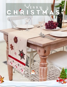 Detail of embroidered snowflakes on beige cotton linen table runner for Christmas dining