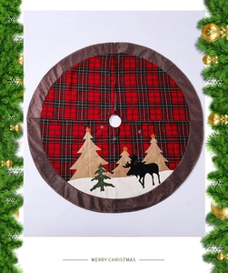 Detail view of red plaid Christmas tree skirt with reindeer and tree embroidery
