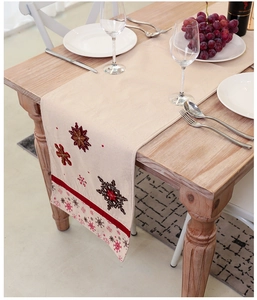Detail of Nordic Christmas table runner with red snowflake embroidery and fringe tassels