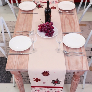 Nordic cotton linen Christmas table runner with embroidered snowflakes on a wooden table