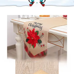 Detail of Christmas table runner with embroidered poinsettia and Merry Christmas text