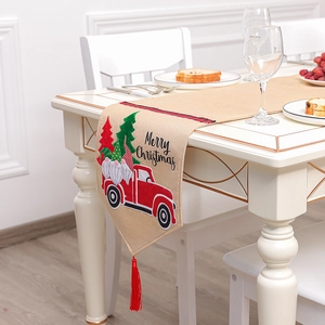 Chemin de table de Noël en lin avec motif de lutin et glands rouges sur table blanche