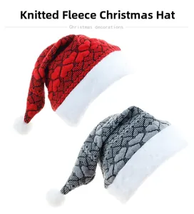 Detail view of red and grey knitted Christmas hats with white plush trim and fuzzy pom-poms