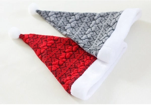 Detailed view of red and grey knitted Christmas hats with plush pom-poms and heart patterns