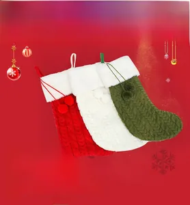 Close-up of knit Christmas stockings with white faux fur cuffs and decorative pom-poms