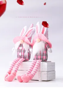 Detail of pink Easter gnome plush with bunny ears and striped legs on wooden box