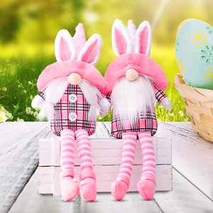 Pink Easter bunny gnomes with long legs and plaid details on a rustic wooden box