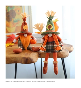 Detail of harvest gnomes with sunflowers and mini pumpkin on rustic wood desk