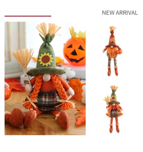 Detail of harvest gnome plush dolls with autumn pumpkin and sunflower decorations