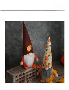 Detail of two autumn harvest gnomes with long beards and colorful pumpkin pattern hats