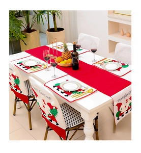 Detailed Christmas table setting with gnome embroidery placemats and festive chair covers