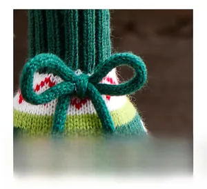 Close-up of a Christmas knitted wine bottle cover with a festive green bow detail