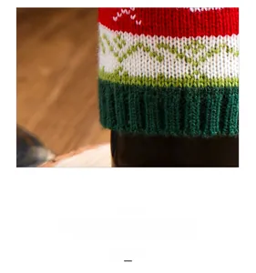 Close-up of knitted wine bottle cover with festive red, white and green zigzag patterns