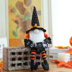 Gnomo di Halloween con cappello a pois e lunghe gambe a righe con striscione BOO