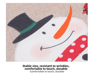 Close-up of linen Christmas chair cover with embroidered snowman and red polka dot scarf