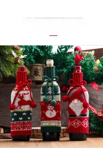 Detail of knitted Christmas wine bottle covers with elk and snowman patterns and pom-poms