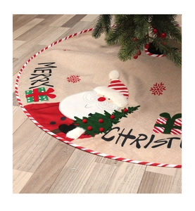Detail of burlap Christmas tree skirt with Santa Claus embroidery and Merry Christmas text