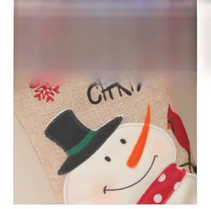 Detail eines Weihnachtsstrumpfs aus Sackleinen mit Schneemann-Stickerei und Schriftzug