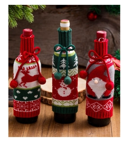 Three Christmas knitted wine bottle covers with reindeer snowman and santa patterns