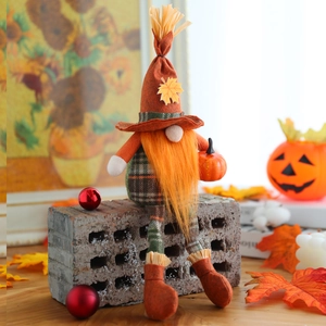 Fall gnome plush decor with orange beard and maple leaf hat sitting on grey brick
