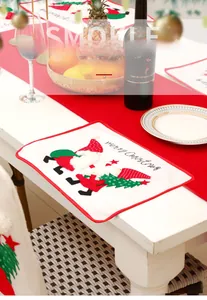 Close-up of embroidered Merry Christmas placemat featuring festive gnomes and trees