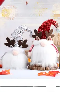 Detalle de gnomos navideños de lentejuelas con astas sobre bases de madera natural