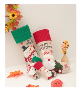 Nahaufnahme von Weihnachtsstrümpfen aus Leinen mit Stickerei und Merry Christmas Dekor