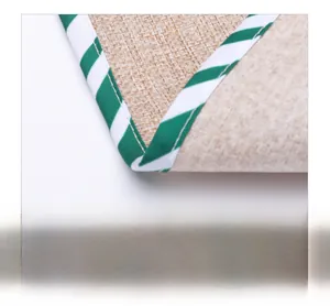 Detail shot of sturdy burlap fabric edge with green and white twill piping and neat stitching