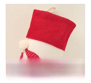 Close-up of red knit cuff and white felt Christmas stocking with detailed embroidery