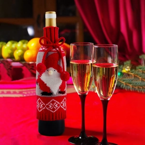 Knitted Christmas wine bottle cover featuring Santa gnome design with pom pom and bow