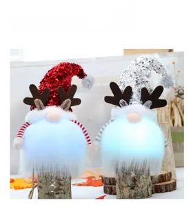 Detalle de gnomos navideños con lentejuelas, astas y barbas luminosas en base madera