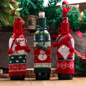 Three-piece knitted Christmas wine bottle covers featuring reindeer, snowman, and Santa designs